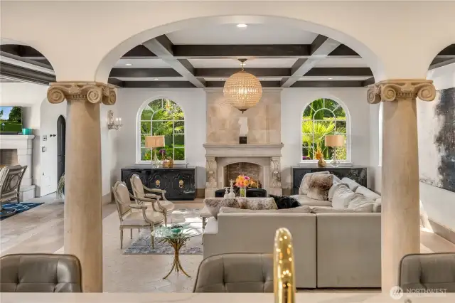 In this photo, you are at the kitchen island looking into the family room. I love how this whole part of the home is laid out. One great space leads to yet another. Notice the hand carved stone fireplace and mantle that anchors the far wall flanked by double arched windows that showcase the garden. You can see the beginning of the outdoor entertaining area to the left. .