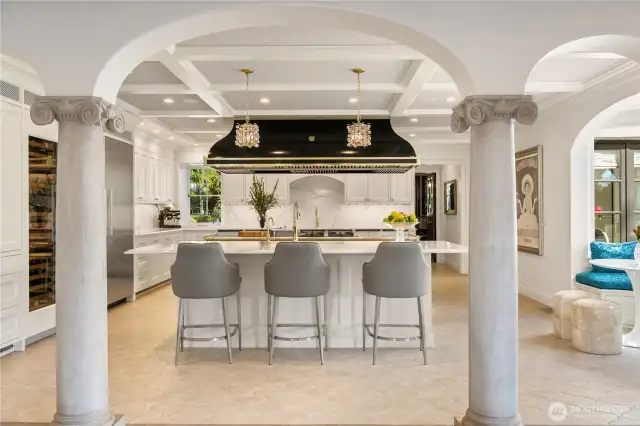 This photo is taken from the family room looking back at the kitchen. Did I forget to mention the full size wine fridge-it is to the left of the column in this photo. Also, you can see now the beautiful box-beamed (painted tin) ceiling in the kitchen. The doorway at the back of the photo leads to the formal dining room.