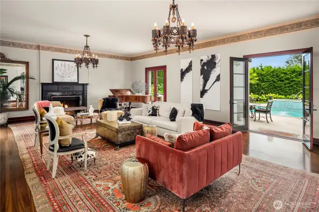 The "sunken" living room is anchored on one end by a beautiful fireplace, and double French doors lead out to the patio and pool.
