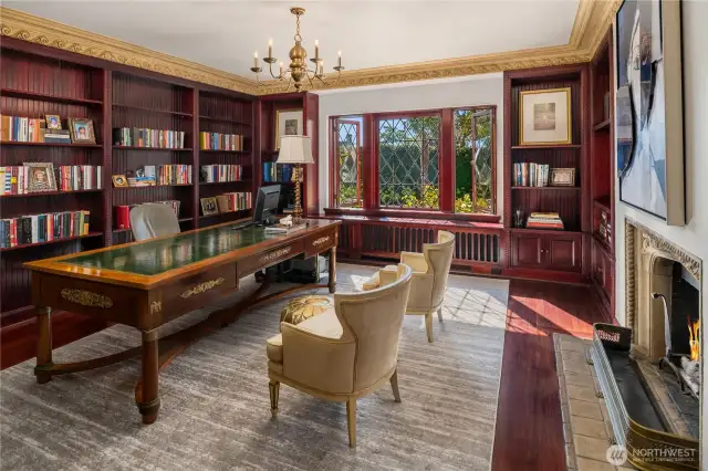 The main floor library/office sits directly behind the foyer, and in-between the living and dining room. On-point leaded windows showcase the lovely gardens & patios and walls of bookshelves provide elegant storage for your book collection.
