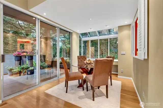 The dining space is wrapped in windows, bringing the outdoors inside