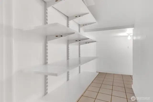 Huge pantry under stairs provides deep storage