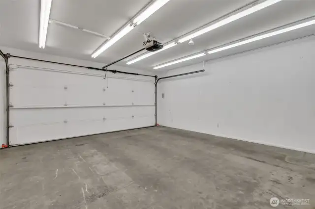 Two car attached garage with driveway parking and neighborhood guest parking