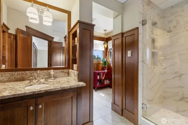Well designed primary bathroom with two sinks, toilet, and a gorgeous shower.