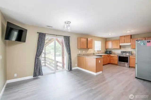 Kitchen with room for nook and sliding door to access covered rear patio and yard.