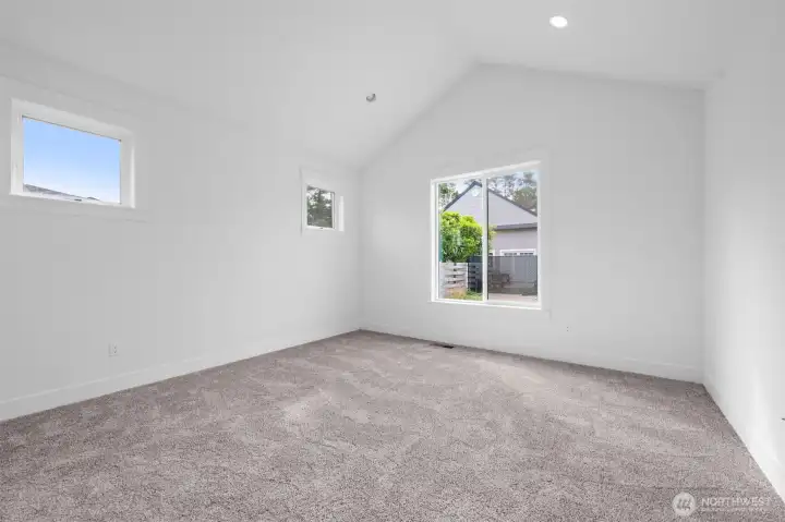 Primary bedroom with vaulted ceilings