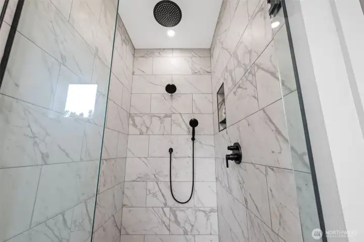 Feel pampered in this beautiful tiled, glass shower with  3 shower heads including a rain shower  head