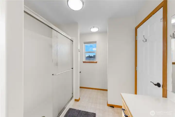 Stand up shower has reeded glass doors for privacy.