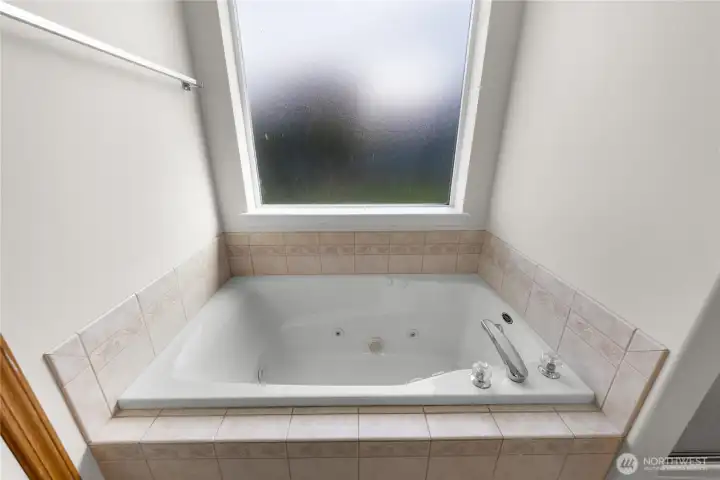 Jetted tub under privacy window makes for a relaxing soak.