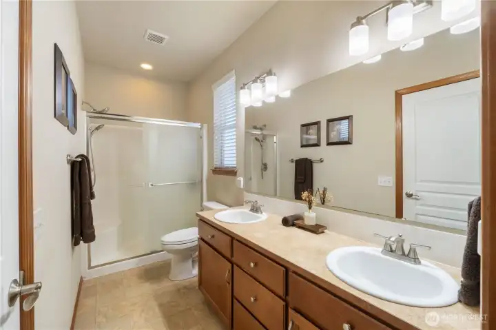 The primary bath includes double sinks, updated lighting and a convenient step-in shower with double shower heads & bench seating. The roomy walk-in closet is off the bath