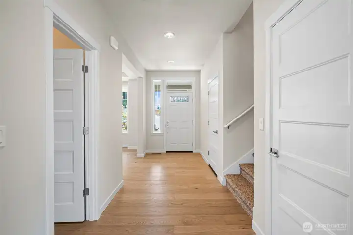 Bright, welcoming entryway and front door with a decorative glass panel that brings in natural light, complemented by a tall sidelight window that brightens the entire space.