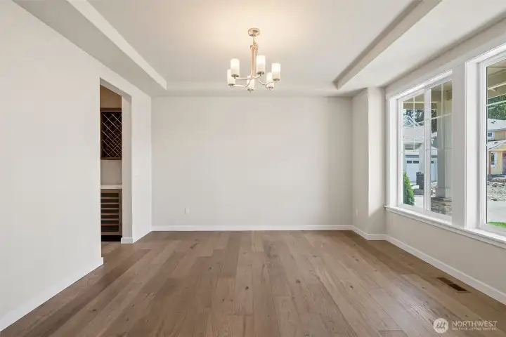 Elegant formal dining room with tray ceiling and large windows to provide abundant natural light.