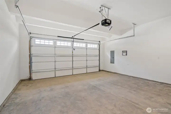Two car garage door with opener and 2 remotes.