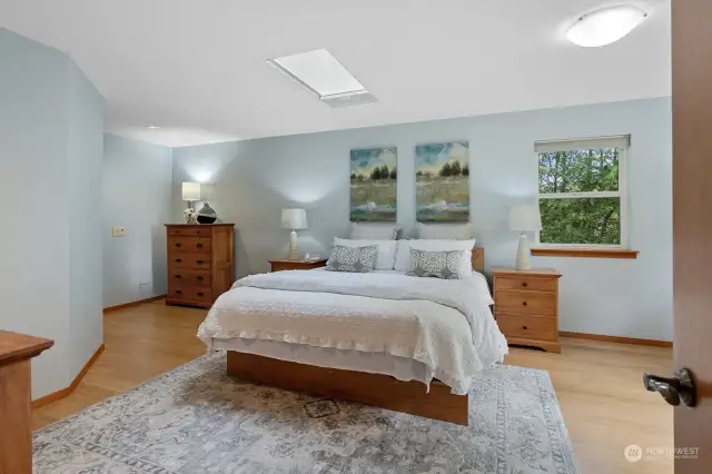 Oversized primary suite with skylight, wooded outlook, and private balcony.
