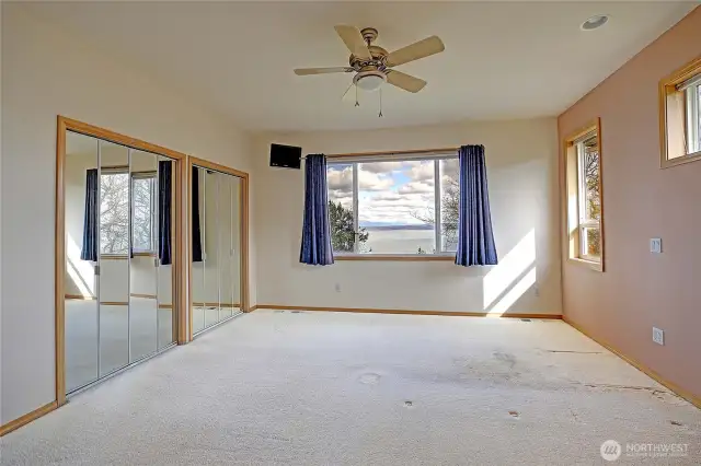 Primary bedroom with water view, double closets