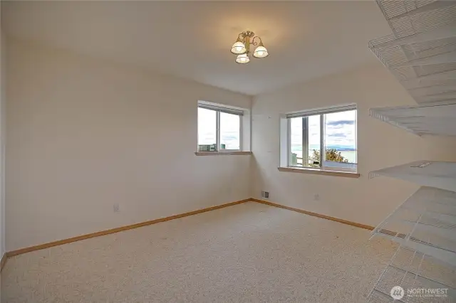 Bonus room with storage shelving and door to full bathroom