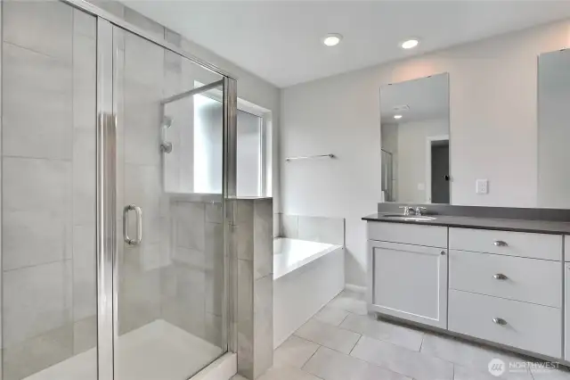 Primary bathroom includes dual vanities, spacious shower and garden tub.