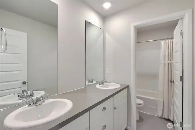 Main bathroom with tub/shower combo and dual sinks.