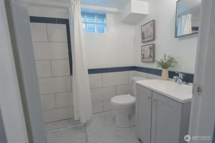 3/4 bathroom in basement with all new fixtures, porcelain penny round tile on floors and large porcelain subway tile on walls.
