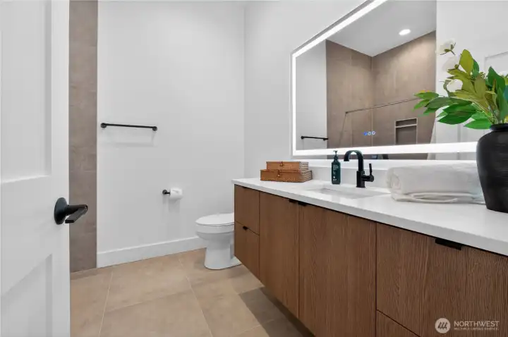 Full bathroom showcasing high ceilings and floating cabinetry for a refined, modern aesthetic
