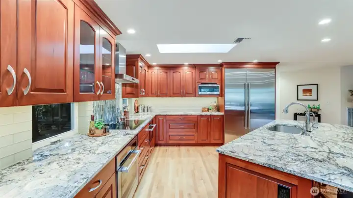 The kitchen is magnificent in every way. All appliances are top of the line high end brands. Granite counters and island with a vegetable sink and tile backsplash. Custom cabinets with several with glass backs to see through to the outside. Large drawers for pans a drawer for garbage and recycling.
