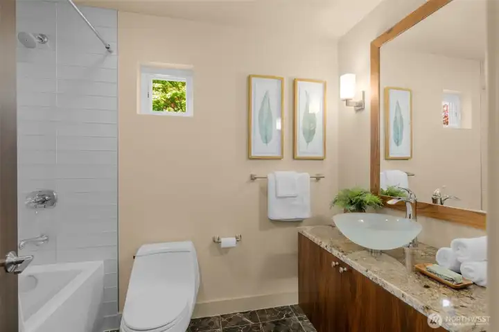 Remodeled full bathroom on main level showcasing designer tile & heated floors