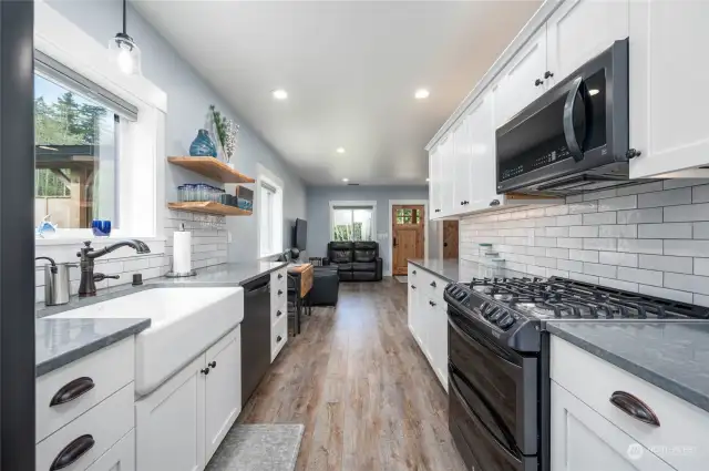 Beautiful efficient kitchen with gas range, loads of cabinets, farm sink and lots of natural light.