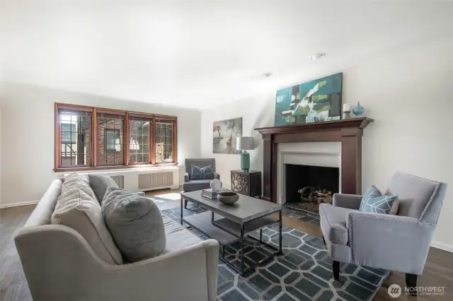 This spacious living room boasts rich hardwoods, gas fireplace with custom mantle and lead-glass windows.