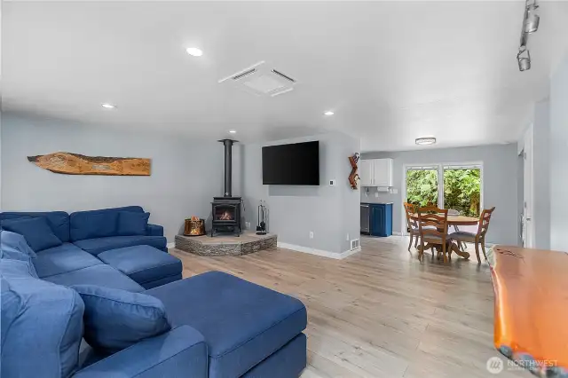 Open entry to living room and dining room with cozy wood fireplace