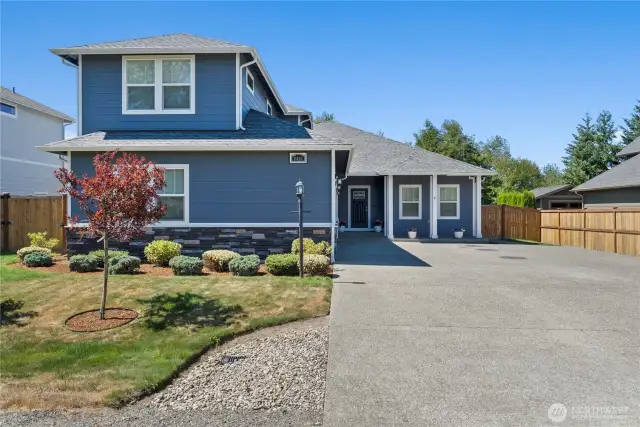 Inviting curb appeal with cement-plank and stone-accented siding, fresh landscaping, and a wide driveway for ample parking.
