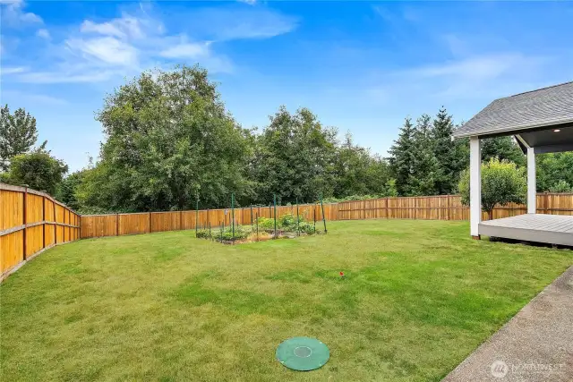 Expansive backyard with a fenced garden area, lush lawn, and plenty of space for outdoor activities.