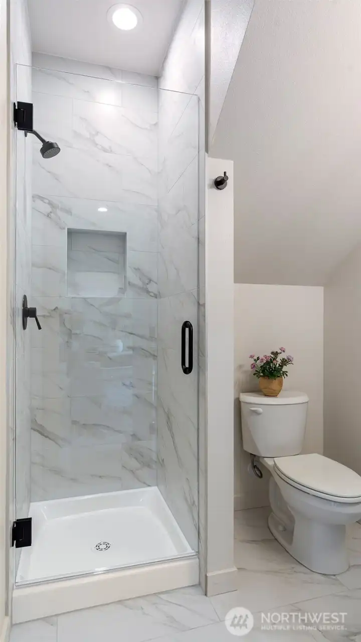 Fully tiled shower and flooring in 3/4 bath on lower level.