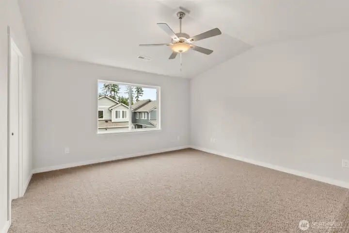 Large primary bedroom features a vaulted ceiling (with ceiling fan too!)