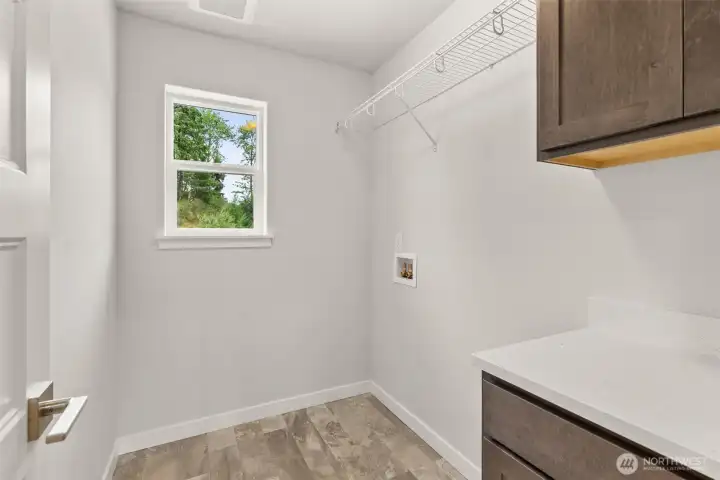 Upstairs laundry room with upper and lower cabinets