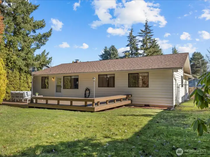 The expansive backyard offers a fully fenced sanctuary with a garden shed, dog run, lush grassy areas, and multiple decks perfect for barbecues and outdoor gatherings.