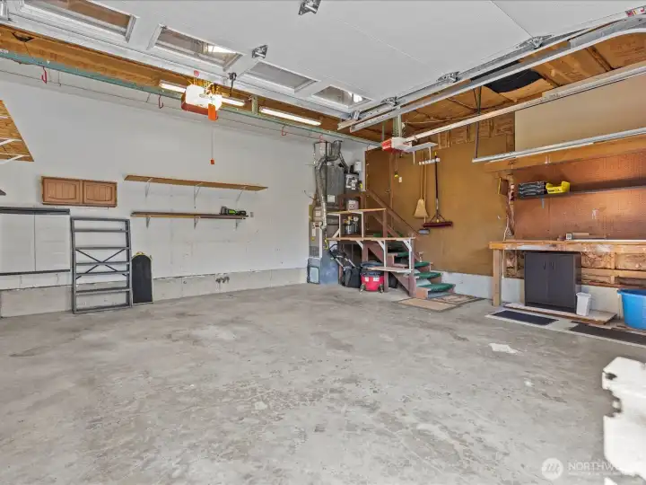 Spacious 2 car garage featuring built in work benches and ample storage space.