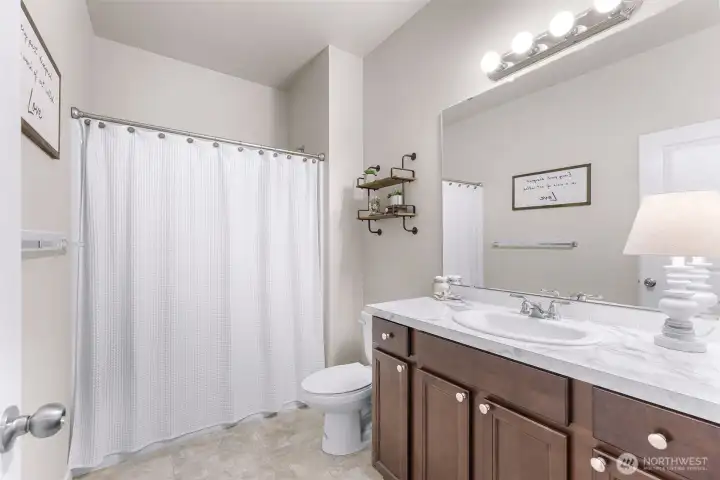 Full guest bath located on the main level between the primary bedroom and second bedroom