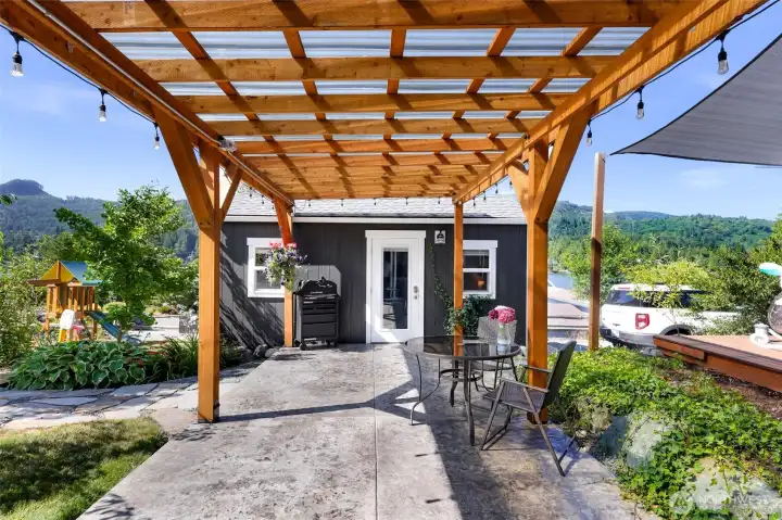 Pergola on lower level of home, looking towards additional detached office space. View is from the lower level ADU.