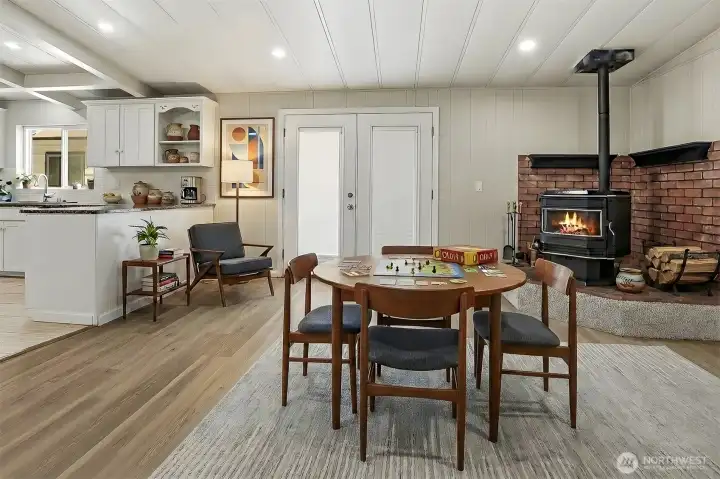 Family room with vaulted ceilings and new LVP flooring, french doors to the private back patio and courtyard, opens to the living room and kitchen - Virtually staged photo