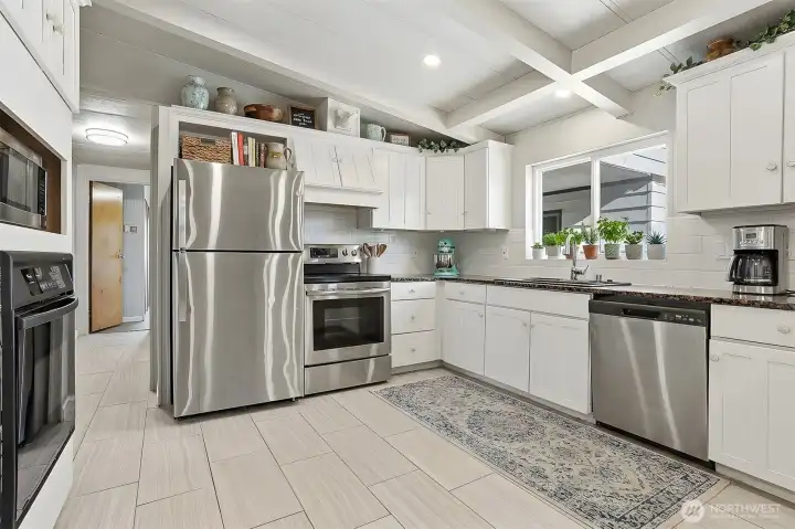 Updated kitchen with tile floors, stainless appliances, eating bar and opens to family room, living room and dining room - virtually staged photo