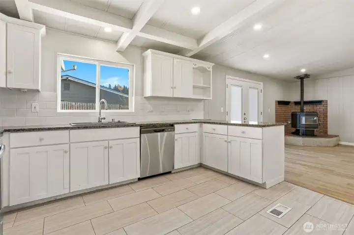 Updated kitchen with tile floors, stainless appliances, eating bar and opens to family room, living room and dining room