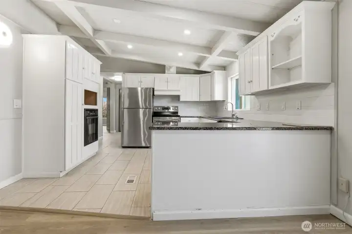 Updated kitchen with tile floors, stainless appliances, eating bar and opens to family room, living room and dining room