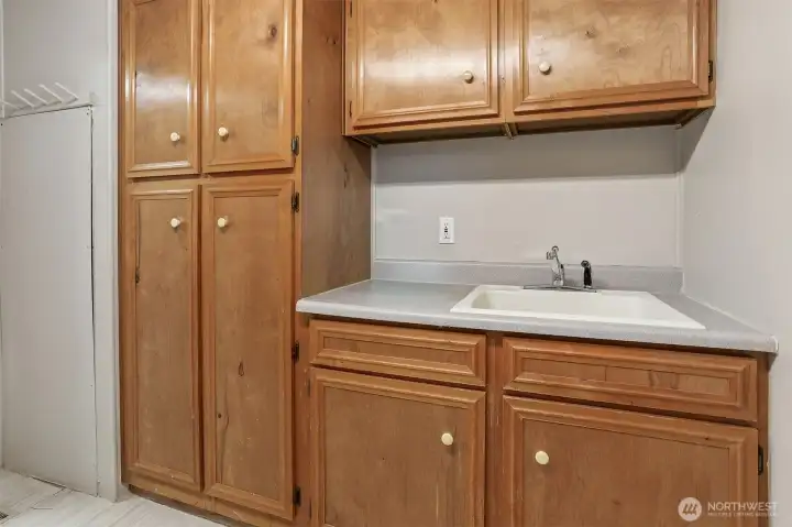 Utility room with full size washer and dryer include and a sink
