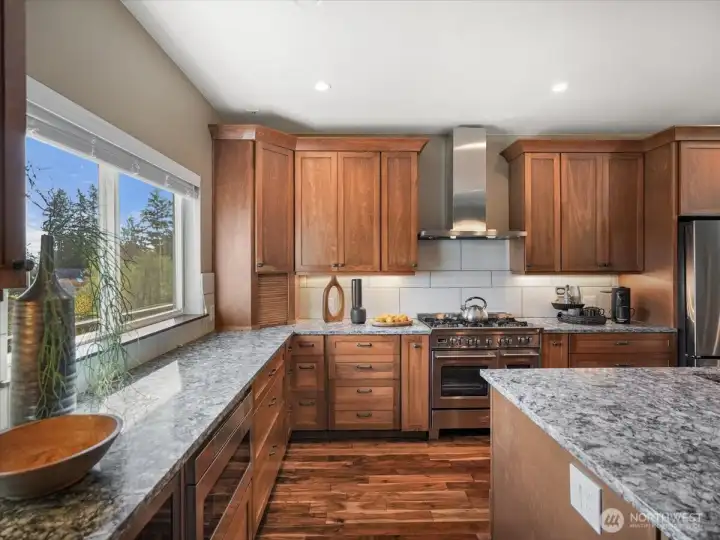 A large picture window in the kitchen beautifully frames the serene lake views, bringing in natural light and creating a stunning focal point.