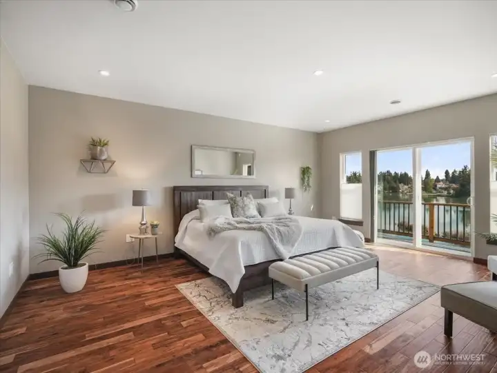 Spacious Primary bedroom on the main level has access to the upper deck to enjoy the beautiful lake view.