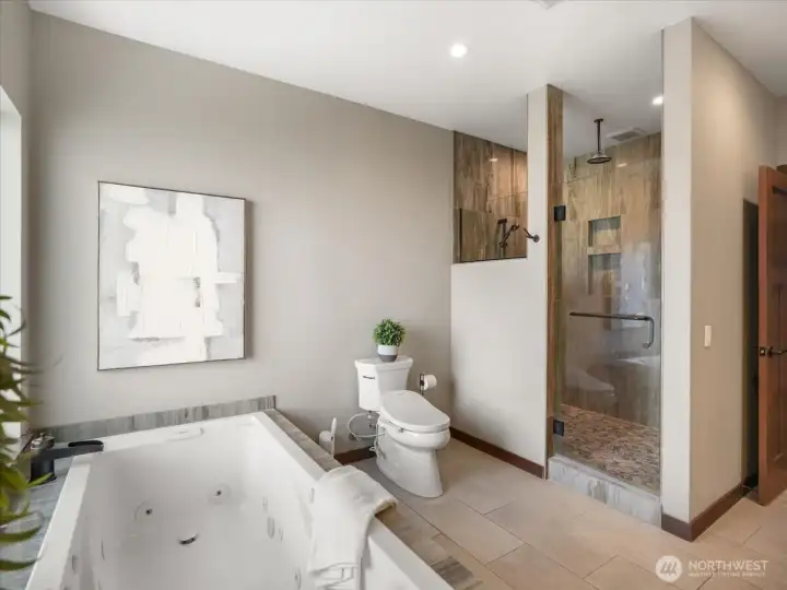 The spa-inspired bath showcases heated floors, a spacious walk-in shower with dual and rain heads, a bidet toilet, jetted tub and refined, luxurious finishes throughout.