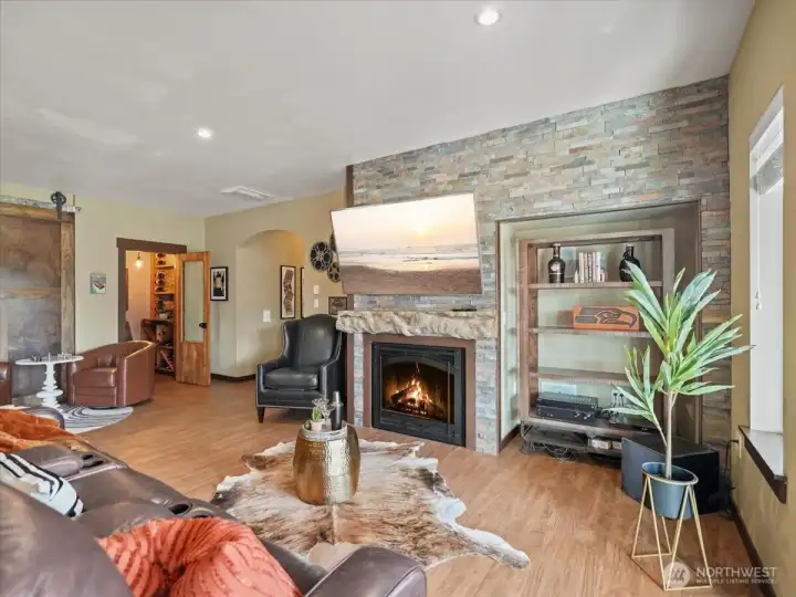 The lower level is thoughtfully designed with a striking stacked stone gas fireplace and a well-appointed wet bar, creating an inviting space for entertaining and relaxation. The adjacent workout room has been plumbed for a potential second kitchen