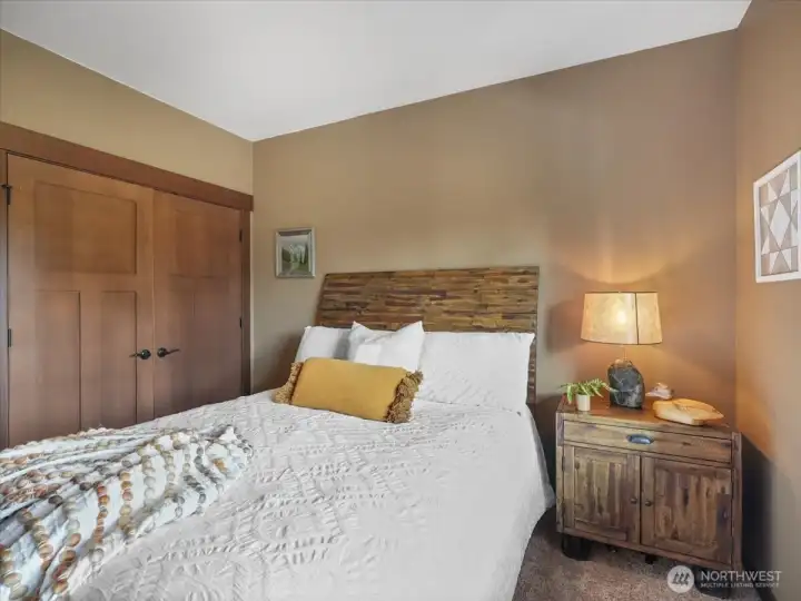 Downstairs bedroom features beautifully crafted double wood closet doors, adding warmth and character to the space.