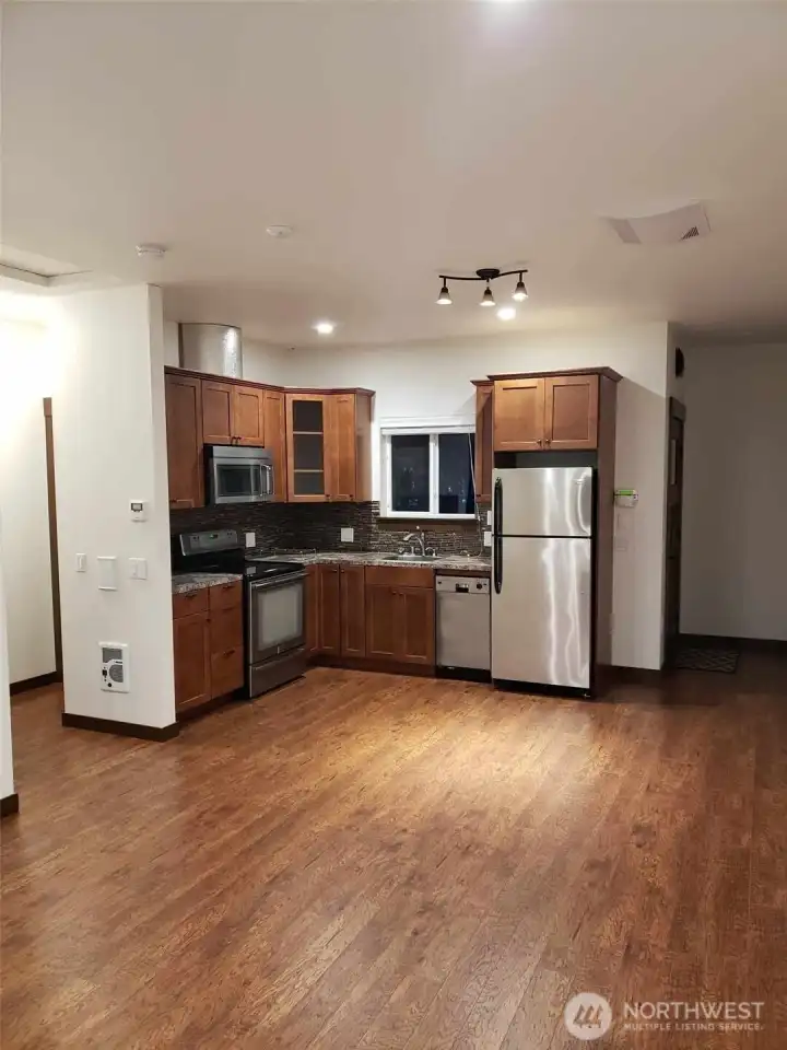 Attached ADU has combined full kitchen living area. Kitchen has induction stove, convection oven & microwave.