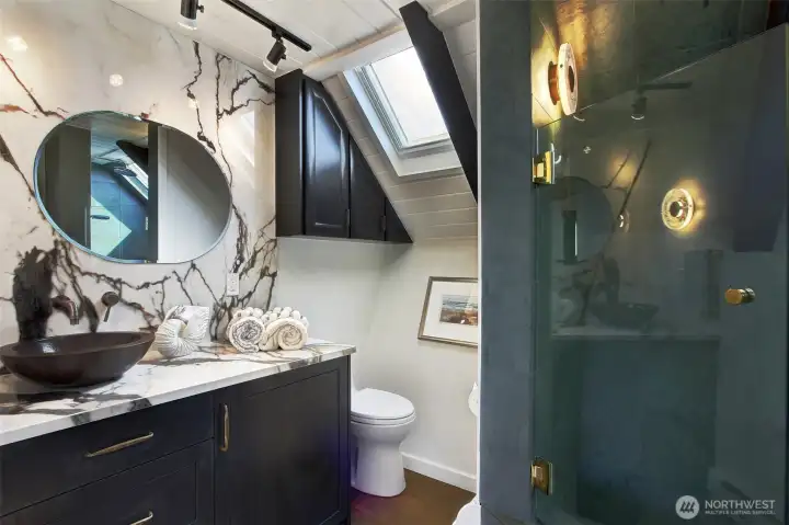 The bathroom is a three quarter walk-in shower.  The water heater is located under the sink and side drawers are for extra storage.